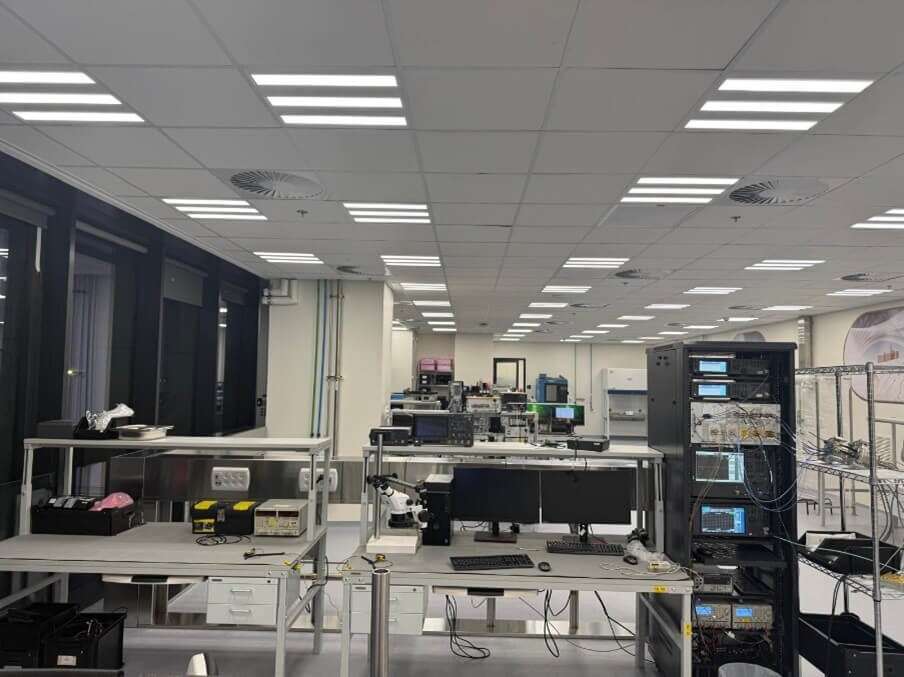 Vista de una sala limpia con estaciones de trabajo, equipos de medición y bancos de pruebas para sistemas de microondas y radiofrecuencia