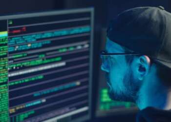 Programador frente a pantallas con código, imagen conceptual sobre inteligencia artificial IA