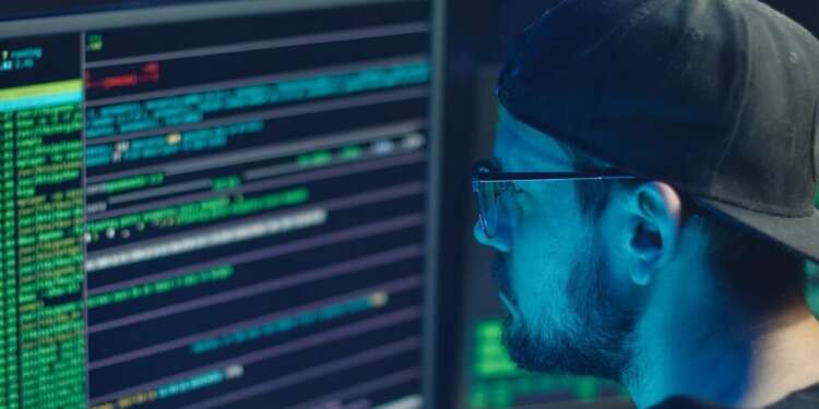 Programador frente a pantallas con código, imagen conceptual sobre inteligencia artificial IA