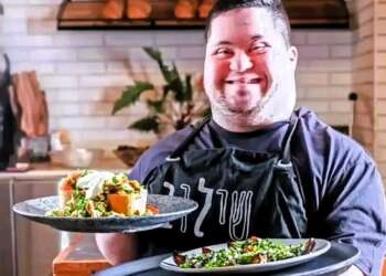 Un joven con discapacidad sirve platos en el café de Shalva en Jerusalén, en Israel, un espacio de inclusión laboral